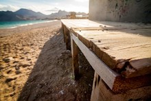 Wooden Platform On The Beach , Near The Sea And Mountains