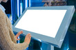 © zyabich - Mock up, copyspace, template, isolated, white screen, futuristic concept. Mockup: woman looking at blank white interactive touchscreen display of grey electronic kiosk at technology exhibition, museum