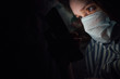 © Иван Шенец - girl at night reads news in a medical mask. corona virus prevention