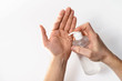 Male hands using hand sanitizer gel pump dispenser. COVID-19 corona virus protection. White background isolated