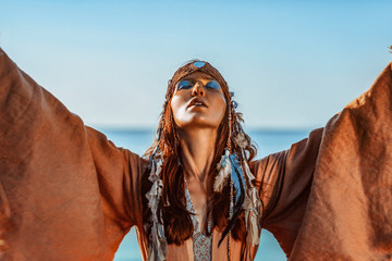 Wall Mural - beautiful young woman in tribal costume outdoors portrait at sunset