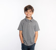 © ShannonK - Cute standing young boy in gray polo shirt hands in pockets isolated on white background