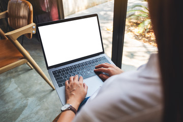 Mockup image of a woman using and typing on laptop computer with blank white desktop screen