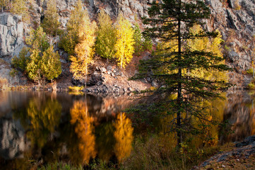 Wall Mural - Autumn colors illuminated by the light of a setting sun are reflected in the calm surface of the Michigamme River near Crystal Falls in Michigan's Upper Peninsula.