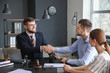 © Pixel-Shot - Male lawyer with client shaking hands in office
