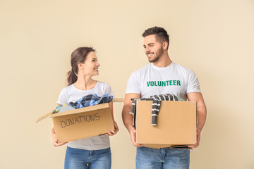 Wall Mural - Volunteers with donations for poor people on color background