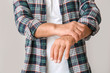 Senior man suffering from Parkinson syndrome on grey background, closeup