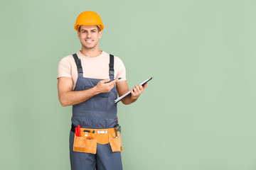 Handsome male worker with documents on color background