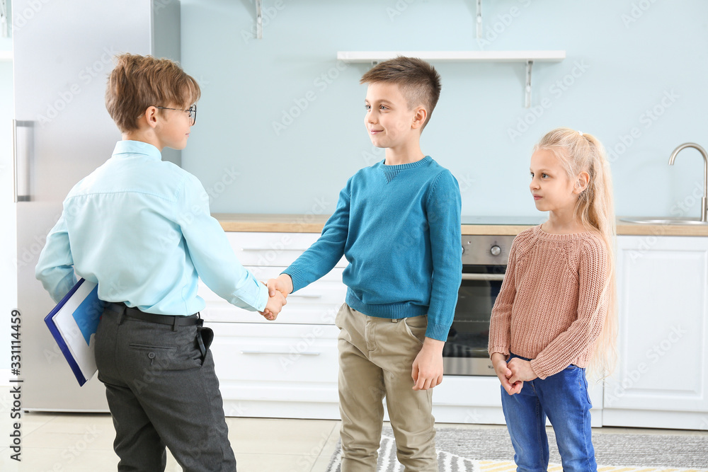 Little real estate agent with clients shaking hands indoors
