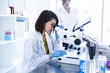 © Monet - 顕微鏡を覗き込む女性研究員