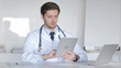 © stockbakers - Young Doctor Using Tablet for Internet Browsing