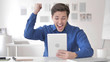 © stockbakers - Casual Adult Man Excited for Results on Tablet
