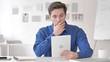 © stockbakers - Wondering Young Man Astonished by Results while Using Tablet
