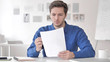 © stockbakers - Casual Adult Man Reading Documents in Office