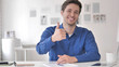 © stockbakers - Thumbs Up by Casual Adult Man Sitting at Workplace