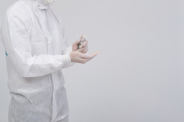 man scientist wearing biological protective uniform suit clothing, mask, gloves with hand sanitizer dispenser for sanitizing virus bacteria