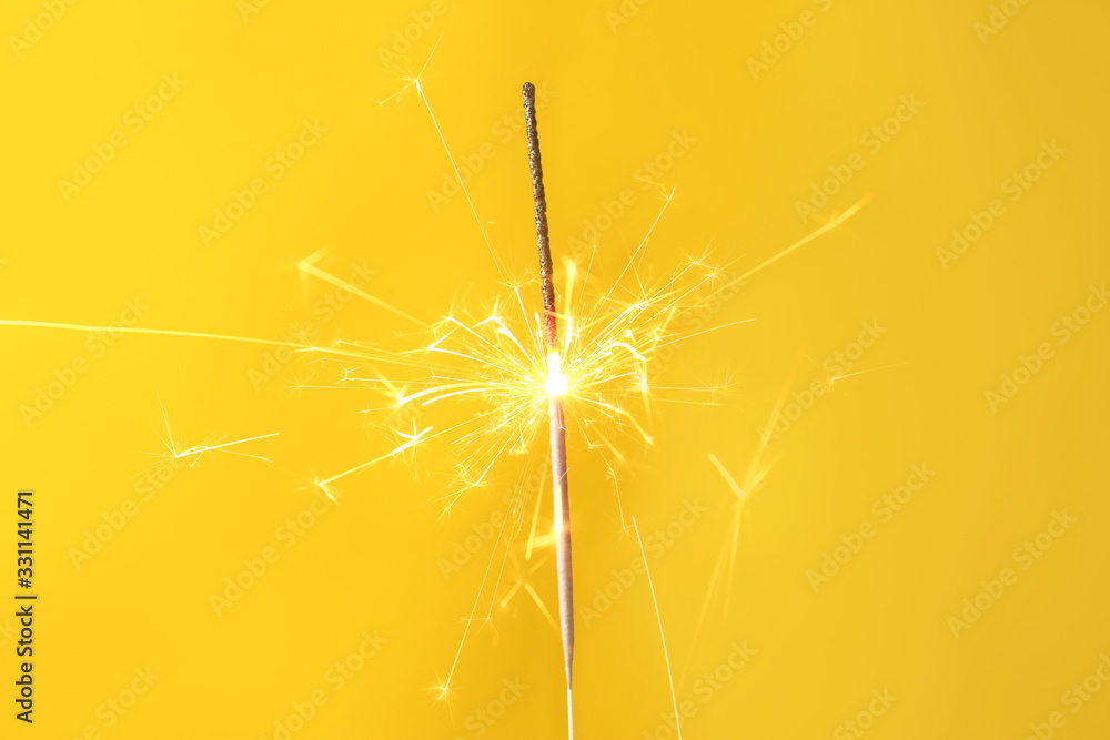 Beautiful Christmas sparkler on color background