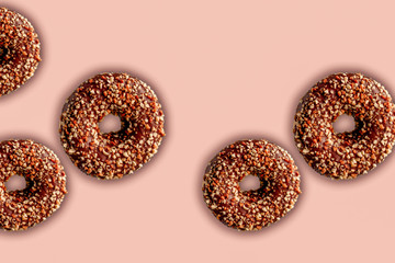 sweet chocolate  donuts with nuts on pastel pink background