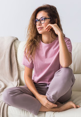 Wall Mural - Young attractive woman dressed in beautiful colorful pajama posing as a model in her living room. Comfortable sleepwear, home relaxation and female fashion concept.