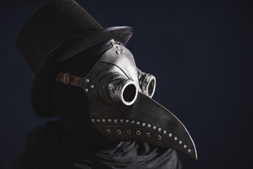 Masked man plague doctor, head profile, with bird mask and hat. Vintage style. Biohazard concept.