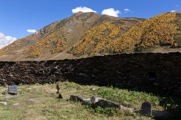 Old stone houses and fences of the village of Ushguli in a beautiful autumn landscape with white clouds in Svaneti. Georgia