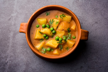 Canvas Print - Aloo Curry Sabzi made using boiled potato with green peas. Served in a bowl or karahi, selective focus