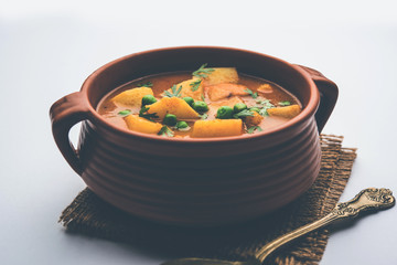 Wall Mural - Aloo Curry Sabzi made using boiled potato with green peas. Served in a bowl or karahi, selective focus