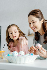 Wall Mural - Selective focus of happy mother and kid near easter eggs