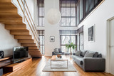 Fototapeta Przestrzenne - Spacious living room with wooden stairs