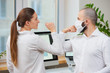 © Roman Tyukin - Elbow greeting to avoid the spread of coronavirus (2019-nCoV). Man with a medical face mask and woman meet in an office with bare hands. Instead of greeting with a hug or handshake, they bump elbows