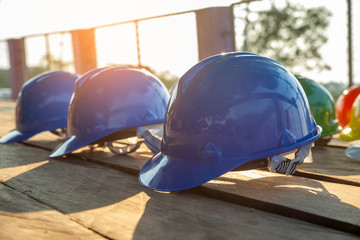 Wall Mural - Safety helmet (hard hat) for safety and health officer,engineer or architect place on old wooden floor.Blue safety hat (helmet) in construction site.Safety equipment concept.