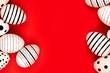 Different graphic hand-painted eggs on bright red background. Easter concept. Place for text.