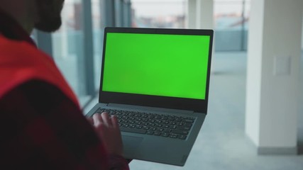 Wall Mural - Close up hands engineer using laptop computer with green screen inside building worker project occupation builder technology mock-up professional male safety device computer slow motion