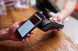 © sandsun - Customer paying by smartphone with NFC technology
