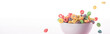 bright multicolored breakfast cereal falling in bowl isolated on white, panoramic shot