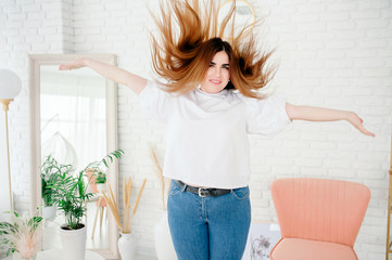 happy plus size model in jeans and white t-shirt, tosses hair lifestyle. young plump woman in casual