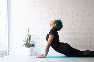 young woman wearing sportswear doing gymnastics at home or gym