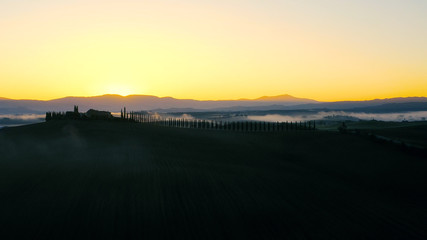 Beautiful landscape scenery of Tuscany in Italy - sunrise with fog in aerial view 