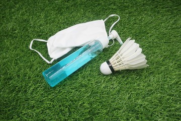 Badminton with hand gel and face mask on green grass 