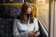 © sushytska - Coronavirus, covid 2019, young woman with respiratory mask traveling in the public transport by bus