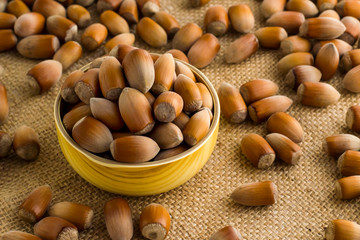 New season product,hazelnuts in the bamboo bowl on the jute fabric  ground with others.Conceptual image of harvest.