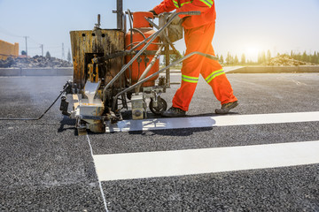 Wall Mural - Road workers use hot-melt scribing machines to painting pedestrian crosswalk on asphalt road surface in the city.