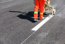 Road Workers Use Hot-melt Scribing Machines To Painting Dividing Line On Asphalt Road Surface In The City.