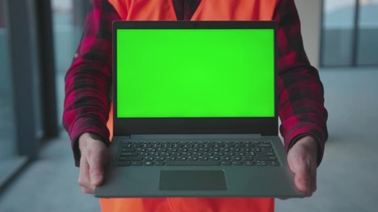 Wall Mural - Close up laptop computer with green screen man hold engineer inside building worker project occupation builder technology mock-up professional male safety device computer slow motion