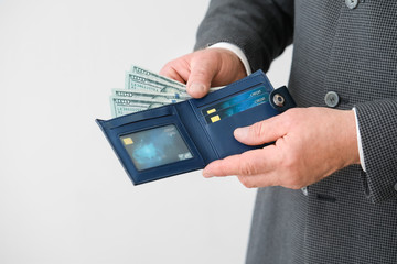 Poster - Senior businessman with purse on light background, closeup