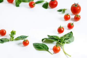 red cherry tomato and basil leaf on white background