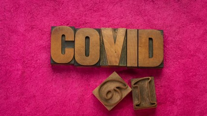 Wall Mural - covid-19, coronavirus pandemic concept - stop motion animation in vintage letterpress wood type against purple handmade bark paper, health and virus outbreak 