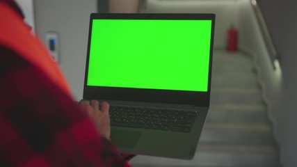 Wall Mural - Man young hands engineer using laptop computer with green screen inside building background stairs worker project occupation builder technology mock-up professional male computer slow motion