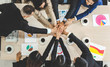 © Art_Photo - Successful of group professional business people to win of celebrating project success.Creative business putting and joining their hands good teamwork together with graph analyze on table.Top view
