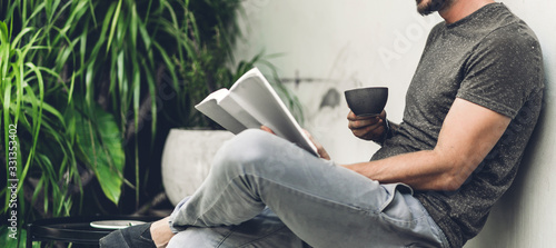 Cuadros en Lienzo Handsome hipster man relaxing read the paper book work study and looking at page